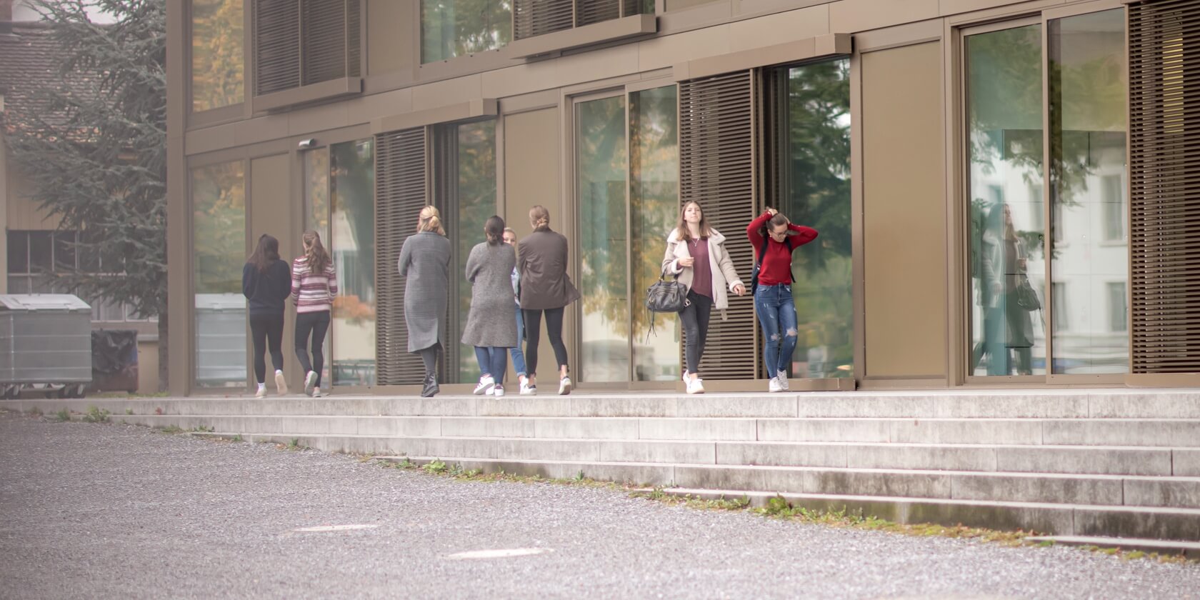 Schüler vor Schulgebäude auf dem Campus